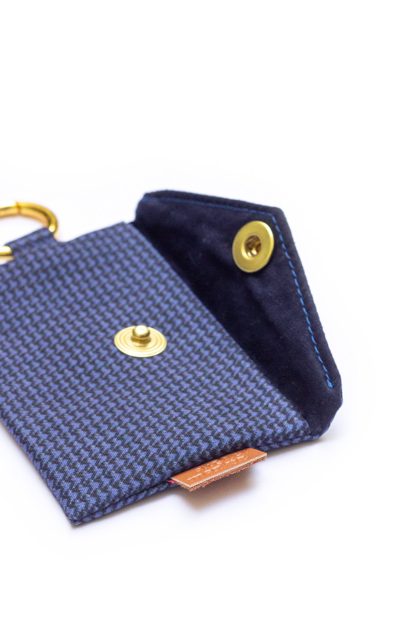 Intérieur de la pochette pour sacs à crottes de chien à motif pied de puce bleu, doublure bleu marine et bouton-pression doré.